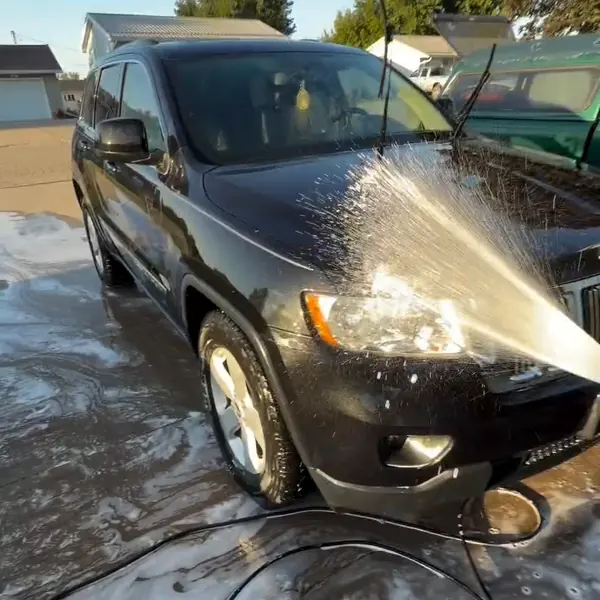 Black Jeep being rinsed during a mobile exterior wash