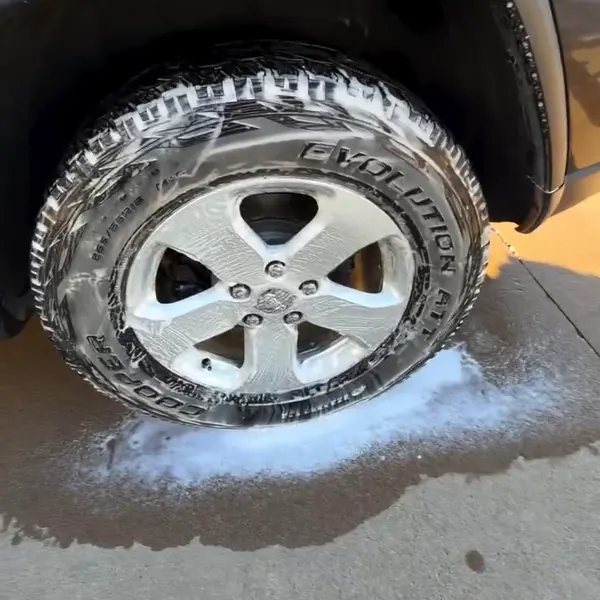 Rin y llanta cubiertos de espuma durante un lavado a mano